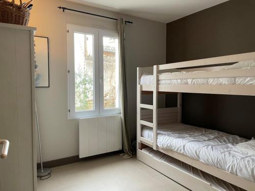 une chambre avec deux lits superposés et une fenêtre dans l'établissement ღ Plein Soleil En Ré Villa Spacieuse avec Piscine & Wifi, au Bois-Plage-en-Ré