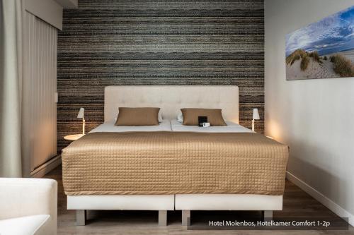 a bedroom with a large bed in a room at Hotel Molenbos Texel in De Cocksdorp