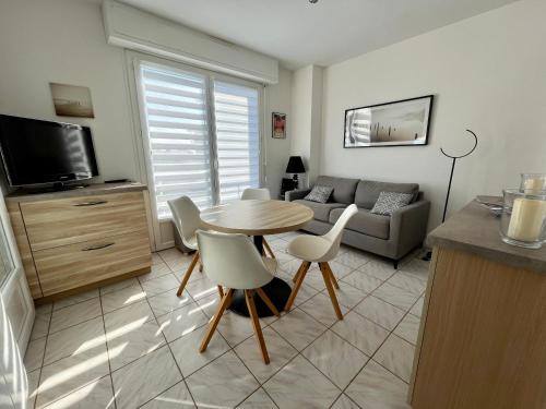 un salon avec une table et un canapé dans l'établissement Le Duna, à Soorts-Hossegor