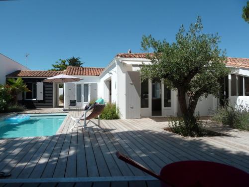 une personne assise sur une échelle au bord d'une piscine dans l'établissement ღ Plein Soleil En Ré Villa Spacieuse avec Piscine & Wifi, au Bois-Plage-en-Ré