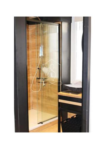 - une douche en verre dans une chambre avec une table dans l'établissement La Vague, au coeur du village de Montauroux, à Montauroux