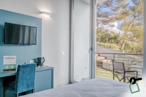a bedroom with a bed and a desk and a window at HOTIDAY Room Collection - Porto Venere in Portovenere