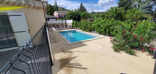 une piscine dans une cour à côté d'une maison dans l'établissement Domaine de Charoussas le mas de mon père, à Lagorce