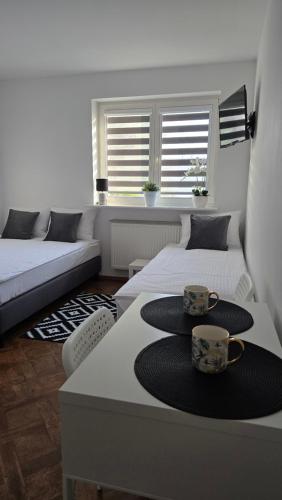 a living room with two beds and a table with cups at Willa Sonia in Władysławowo