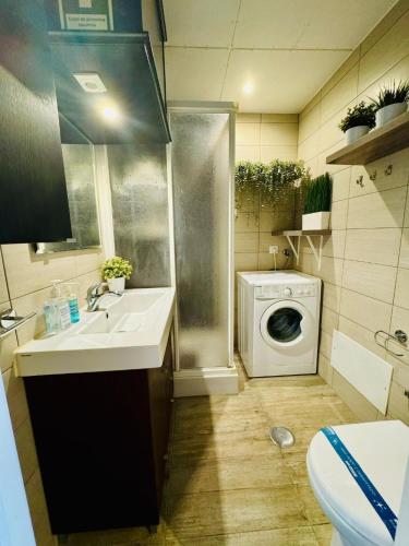 a bathroom with a sink and a washing machine at Casa Azul Torreira in Torreira