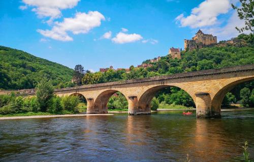 a bridge over a river with a castle in the background at Nice Home In Saint-Géraud-De-Corps in Saint-Géraud-de-Corps