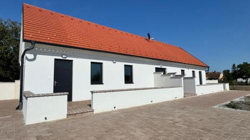 un edificio bianco con tetto arancione di Apartments Mexico Puszta - Nähe Neusiedlersee - Seewinkel a Fertőújlak