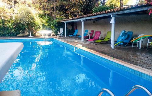 - une piscine avec des chaises colorées à côté d'une maison dans l'établissement Lovely Home In Vaison-La-Romaine, à Vaison-la-Romaine