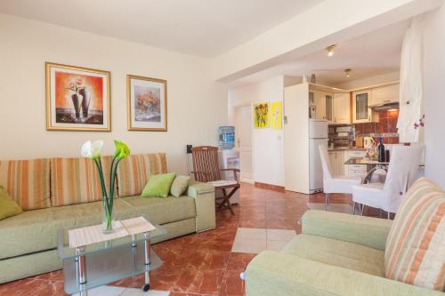een woonkamer met twee banken en een keuken bij Apartments Kalalarga Deluxe- city centre&balcony in Makarska