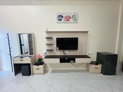 a living room with a television and a desk at Lundu Town Homestay, Kpg Dagang in Lundu