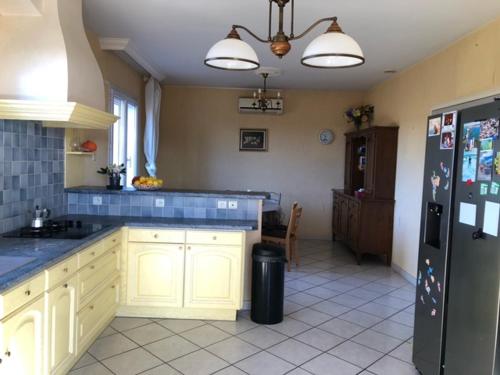 une cuisine avec des armoires blanches et un réfrigérateur noir dans l'établissement Sunset Ridge house, à Pierrevert