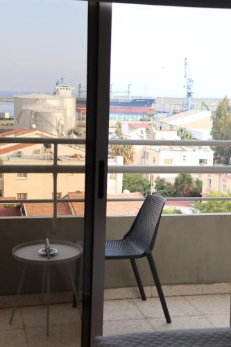 a chair and a table on a balcony with a view at Sunflower Hotel Apartments in Larnaka