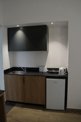 a kitchen with a sink and a counter top at Sunflower Hotel Apartments in Larnaka
