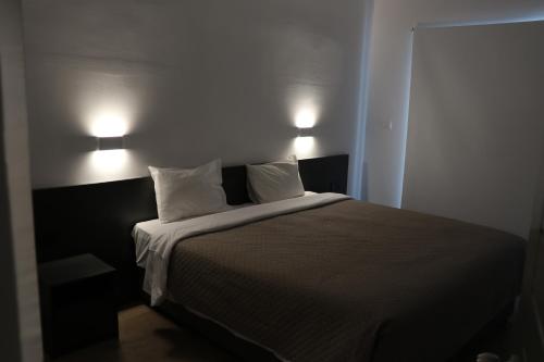 a bedroom with a bed with two lamps on it at Sunflower Hotel Apartments in Larnaka
