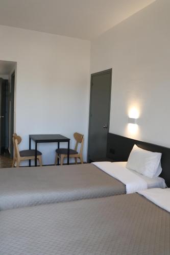 a bedroom with two beds and a table and chairs at Sunflower Hotel Apartments in Larnaka