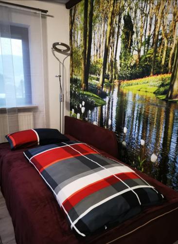 a bedroom with a bed with a painting of a river at Ferienwohnung Saussele in Arrach