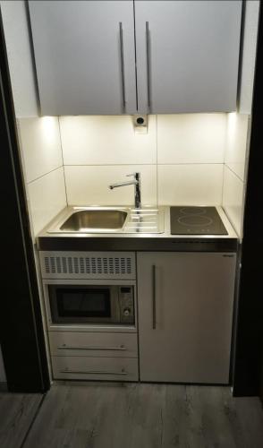 a small kitchen with a sink and a microwave at Ferienwohnung Saussele in Arrach