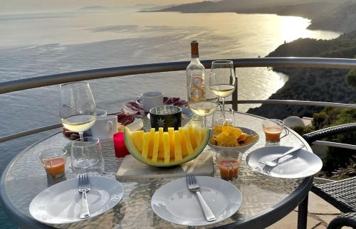 een tafel met glazen en borden eten en wijn bij Castillo de ensueño in La Herradura