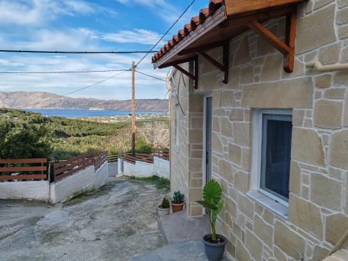 ein Steinhaus mit einem Fenster und einer Topfpflanze in der Unterkunft Jacob's cottage Ideal Base for Balos & Elafonisi in Kissamos