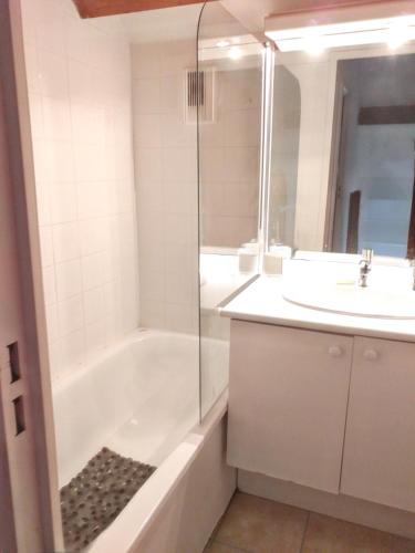 une salle de bain avec une baignoire et un lavabo dans l'établissement Maison accueillante à La Salvetat-sur-Agout avec terrasse, à La Salvetat-sur-Agout