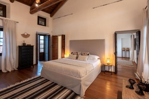 a bedroom with a large white bed and wooden floors at Les Arcs in Agrate Conturbia