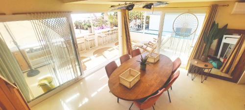 a dining room with a wooden table and chairs at Beach penthouse with rooftopbar and Starlink WiFi, spectacular 180 degrees ocean view in Santa Maria