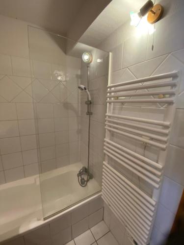 La salle de bains blanche est pourvue d'une douche et d'une baignoire. dans l'établissement Appartement les Saisies, à Villard-sur-Doron