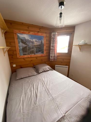 une chambre avec un lit dans le coin d'une pièce dans l'établissement Appartement les Saisies, à Villard-sur-Doron