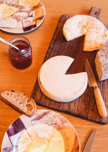 a table topped with bread and cheese on cutting boards at Maison L'Aiguille - 2 appartements, 5 chambres et table d'hôtes au pied de la montagne à la station de Laye in Laye