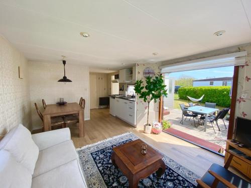 a living room with a white couch and a table at Vakantiepark Callassande - CS 074 in Callantsoog