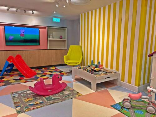 a childs room with a playroom with a tv and toys at Holiday Inn Southampton Eastleigh by IHG in Southampton