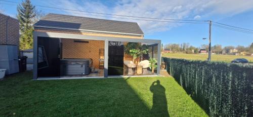 a shadow of a person standing in a yard at Au Petit Seny, gîte charme et nature avec jacuzzi pro in Tinlot