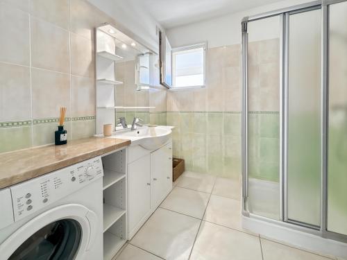 - une buanderie avec un lave-linge et une douche dans l'établissement Résidence Port Calvi - Appartement T3 vue mer !, à Calvi
