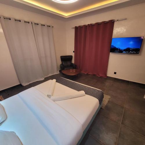 a bedroom with a large bed and a red curtain at Chambre d'hôtes villa Burj in Ngaparou
