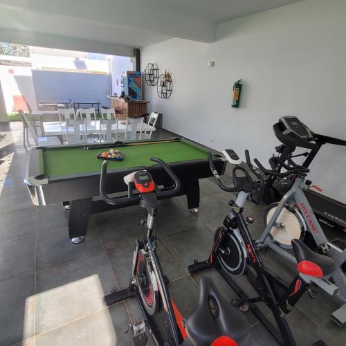 a room with a ping pong table and two bikes at Chambre d'hôtes villa Burj in Ngaparou