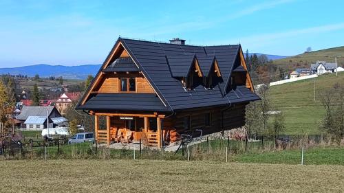 a large log cabin with a black roof at Chata Albertówka in Groń