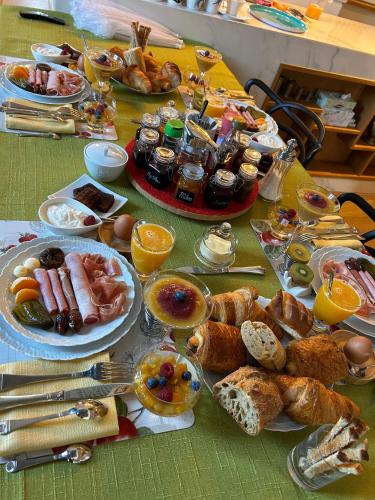 - une table avec des assiettes de petit-déjeuner dans l'établissement Les Trois Tilleuls 2, à Loupiac-de-Cadillac