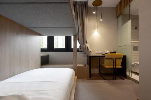 1 dormitorio con 1 cama y escritorio con silla amarilla en ST Signature Tanjong Pagar, SHORT OVERNIGHT, 12 hours, 8PM-8AM, en Singapur