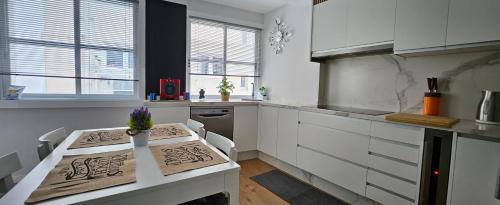 a kitchen with white cabinets and a table in it at Villa Miel in A Coruña