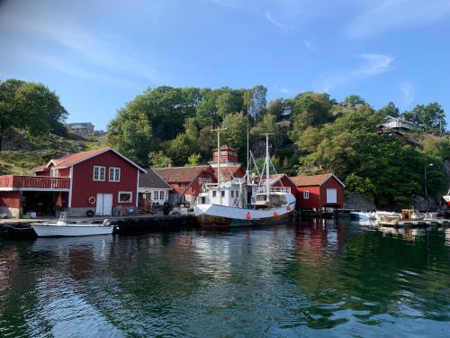 una barca è ormeggiata in un porto turistico con case di Sogndalstrand Kulturhotell a Sogndalsstrand