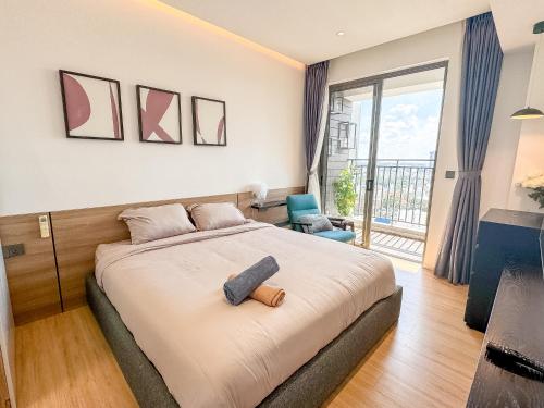 ein Schlafzimmer mit einem Bett und einem großen Fenster in der Unterkunft Summerset Saigon - The Perfect Place to Live in District 1 in Ho-Chi-Minh-Stadt