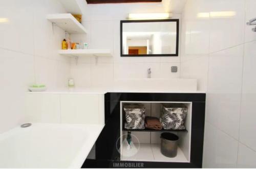 une salle de bain blanche avec un lavabo et un miroir dans l'établissement Appartement 2 chambres - Les Houches, aux Houches
