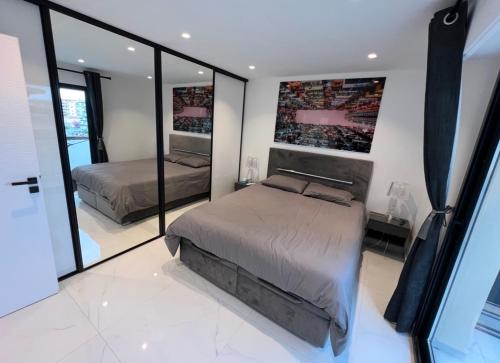 une chambre avec deux lits et un grand miroir dans l'établissement Appartement Cannes Hyper Centre Croisette et rue antibes, à Cannes