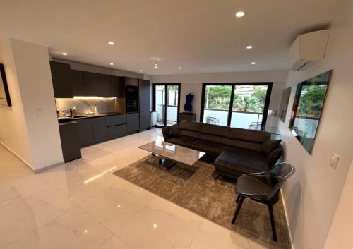 un salon avec un canapé et une cuisine dans l'établissement Appartement Cannes Hyper Centre Croisette et rue antibes, à Cannes