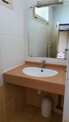 une salle de bain avec un lavabo et un miroir dans l'établissement Studio 2 pers à 50 m de la plage, à Fleury