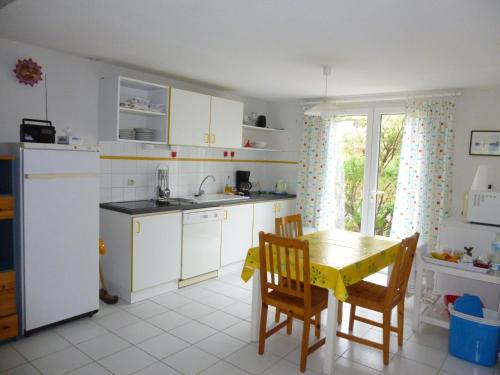 une cuisine avec des armoires blanches et une table et des chaises dans l'établissement 85m2 villa with garden and private pool, à Vias