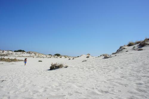 a person walking on the sand on a beach at Locanda FarOrientale in Santa Lucia