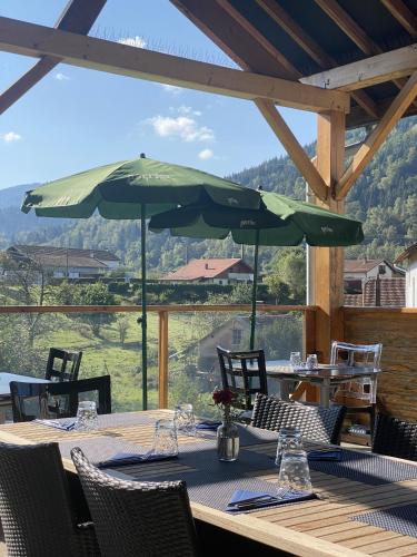 a table with two green umbrellas on a patio at Maison Capdet in Fresse-sur-Moselle