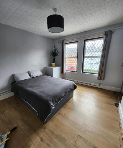 a bedroom with a bed and two windows at Double room with shared facilities in Hitchin