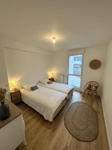 une chambre avec un grand lit et une grande fenêtre dans l'établissement Le champs de mars, à La Rochelle